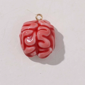 Close-up of a glossy pink brain resin pendant with a golden metal loop connector