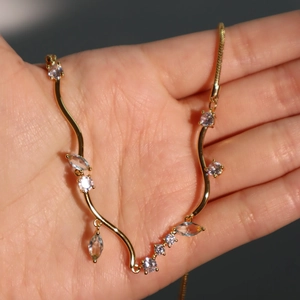 Detail of 18k gold plated Cuban chain with blue zircon stones and drop tassels