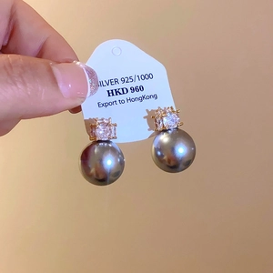 Macro detail of 925 silver earrings with dark grey metallic pearls and clear crystals