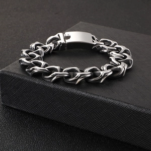 Close-up of heavy stainless steel link bracelet on a textured black jewelry box