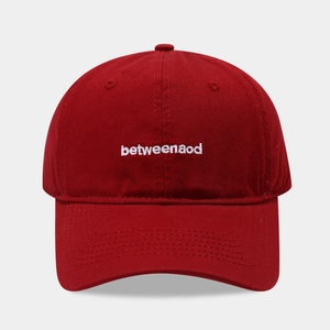 Minimalist red cotton baseball cap featuring white betweenaod embroidery on a gray background