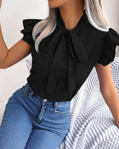 Close-up of black ruffle sleeve blouse with bow tie neck and smooth fabric texture