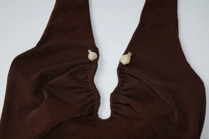 Detail of dark brown glitter fabric with pleated halter neckline and beaded accents