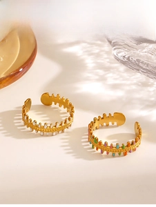 Detailed view of 18K gold plated fishbone rings with colorful enamel drip on white surface