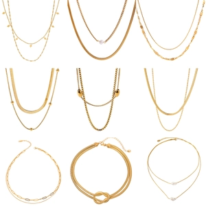 Collection of layered gold titanium steel necklaces with pearls and geometric pendants