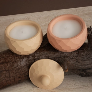 Detail of faceted geometric candle jars with matte finish on rustic wood texture