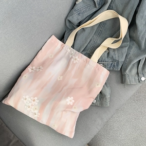 Grand sac cabas en toile rose avec broderie florale et anses crème sur veste denim