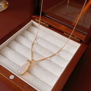 Detail of gold plated necklace with white chalcedony teardrop pendant on velvet