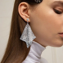 Detail view of silver sequin mesh rhombus drop earrings on model with sparkling finish