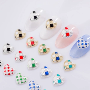 Close-up of checkerboard heart nail charms with enamel finish and inlaid rhinestones