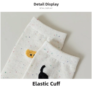 Detail view of cotton socks with colorful flecks, elastic cuff, and cute cat embroidery