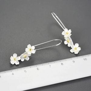 Elegant S925 silver long floral drop earrings with brushed texture and golden accents