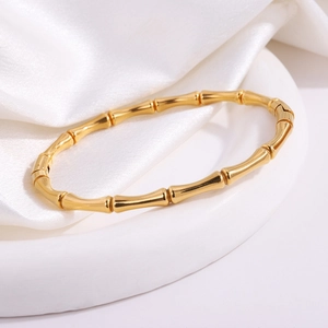 Dettaglio del bracciale in acciaio inossidabile dorato stile bambù con finitura lucida