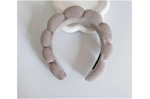 Detail of beige sponge cloud headband with soft teddy velvet texture on white background