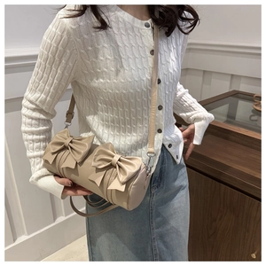 Détails de deux grands nœuds sur un sac bandoulière cylindrique beige élégant