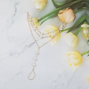 Bohemian gold layered anklet with white pearls and toe ring on marble background
