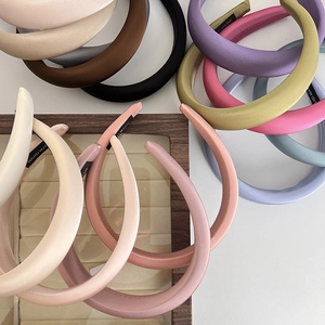 Flat lay of colorful padded sponge headbands in soft fabric with handmade labels