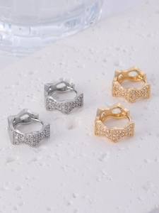 Macro detail of star-shaped hoop earrings with pave-set cubic zirconia in gold and silver
