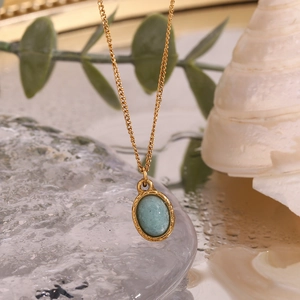 Macro detail of 18K gold-plated necklace featuring a mini oval light blue natural stone