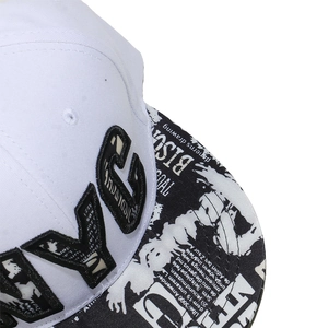 Detailed close-up of white hip hop cap featuring 3D NYC embroidery and graffiti brim