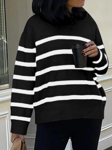 Outdoor shot of a woman wearing a black and white striped long sleeve knit sweater