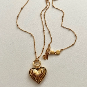 Detail view of 925 sterling silver gold heart pendant with textured sunburst pattern