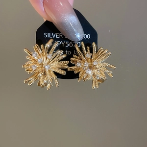 Detailed macro view of 18k gold plated fireworks ear clips with sparkling zircon stones