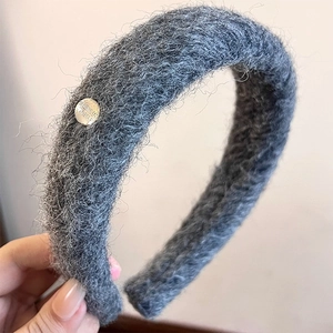 Close-up of grey plush headband with long mohair texture and silver metal buckle detail