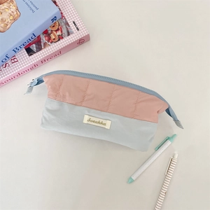 Detailed view of the quilted stitching and dual-tone pink and blue fabric on the pencil case