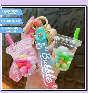 Close-up of creative liquid boba tea keychain with pink and green sand flow and silicone strap