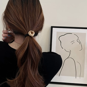 Elegant gold triple ring charm hair tie on high-elastic black cord shown on model