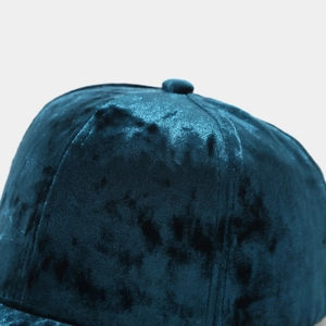 Détail d'une casquette en velours montrant la texture du tissu et le bouton