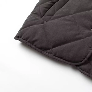 Detailed macro view of dark grey quilted fabric with classic diamond stitching patterns