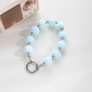 Detail of light blue pompom and silver bead wristlet strap with metal spring clasp