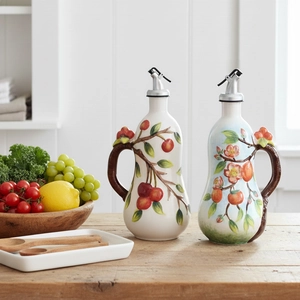 Juego de aceiteras de cerámica pintadas a mano con motivos de frutas en mesa de madera