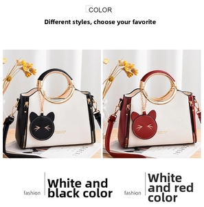 Detail of color-block handbags with round gold handles and cute cat charms