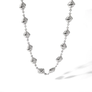 Detailed view of silver titanium steel necklace featuring spiral conch and starfish charms