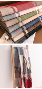 Close-up of multicolored plaid cashmere scarfs with soft fringe and high-end texture