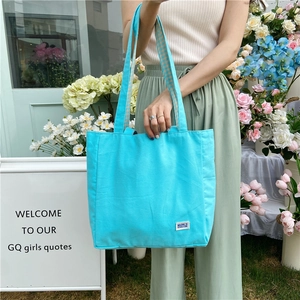Detalle de bolso tote de lona azul cielo con correas de cuadros en una floristería