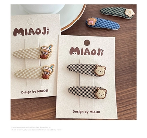 Close-up of children fabric hair clips with 3D teddy bear and flower on a card