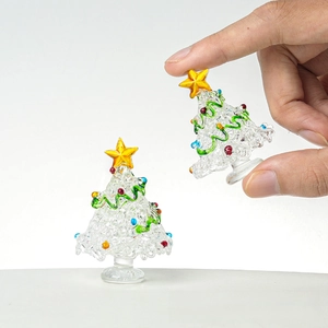 Close-up of a handmade glass mini Christmas tree with colorful baubles and gold star