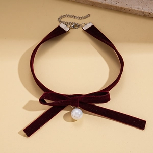 Detail of burgundy velvet choker featuring a pearl pendant and adjustable metal chain