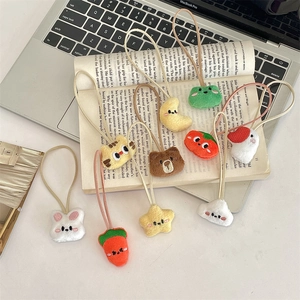 Close-up of cute plush animal pendants and hair ties on an open book and laptop