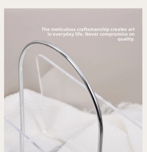 Close-up of modern acrylic storage rack with silver metal handle and clear side panels