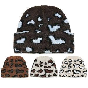 Dettaglio di berretti in maglia con motivi leopardati e a cuore in quattro varianti colore
