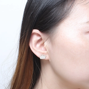 Elegant gold crown stud earring worn on model featuring a minimalist matte metal finish