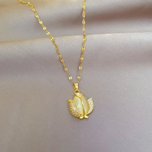 Close-up of golden tulip necklace with cat eye stone on soft grey silk fabric