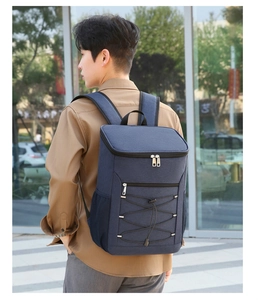 Blue insulated backpack with reflective strips and bungee cord shown in outdoor use