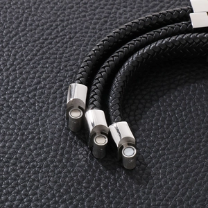 Detail of silver magnetic clasp on a black braided leather punk style bracelet