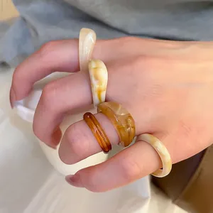 Five-piece set of amber and cream acrylic resin rings for women with marble texture